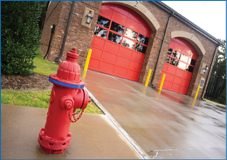 A fire hydrant stands outside the two bay garage that serve as the fire department truck protection